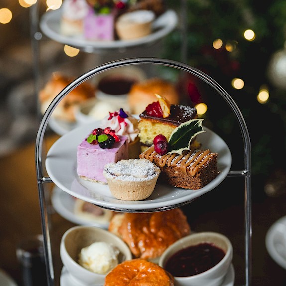 A selection of cakes and scones on a cake stand