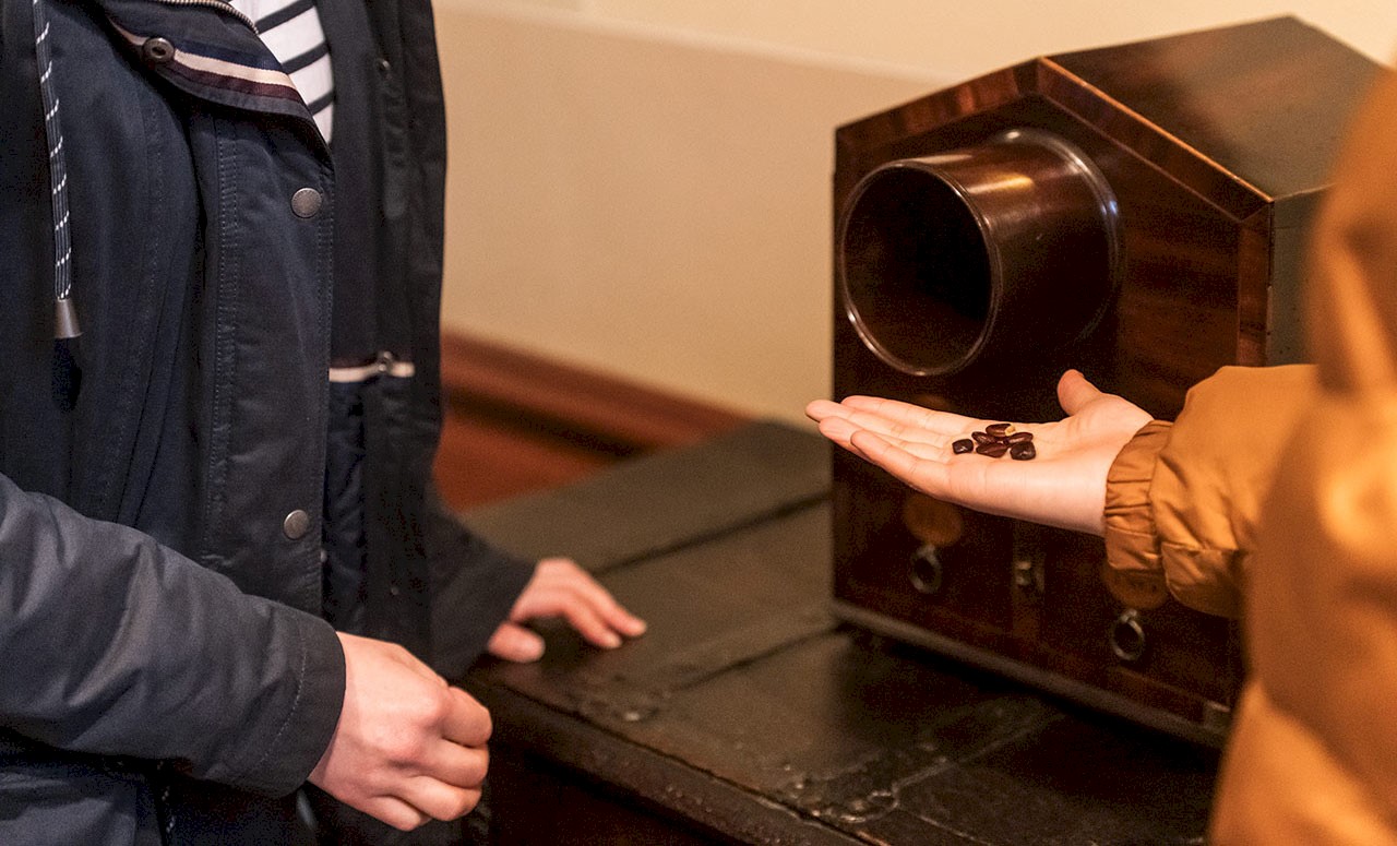 Hands of two people looking at an item in Trinity House