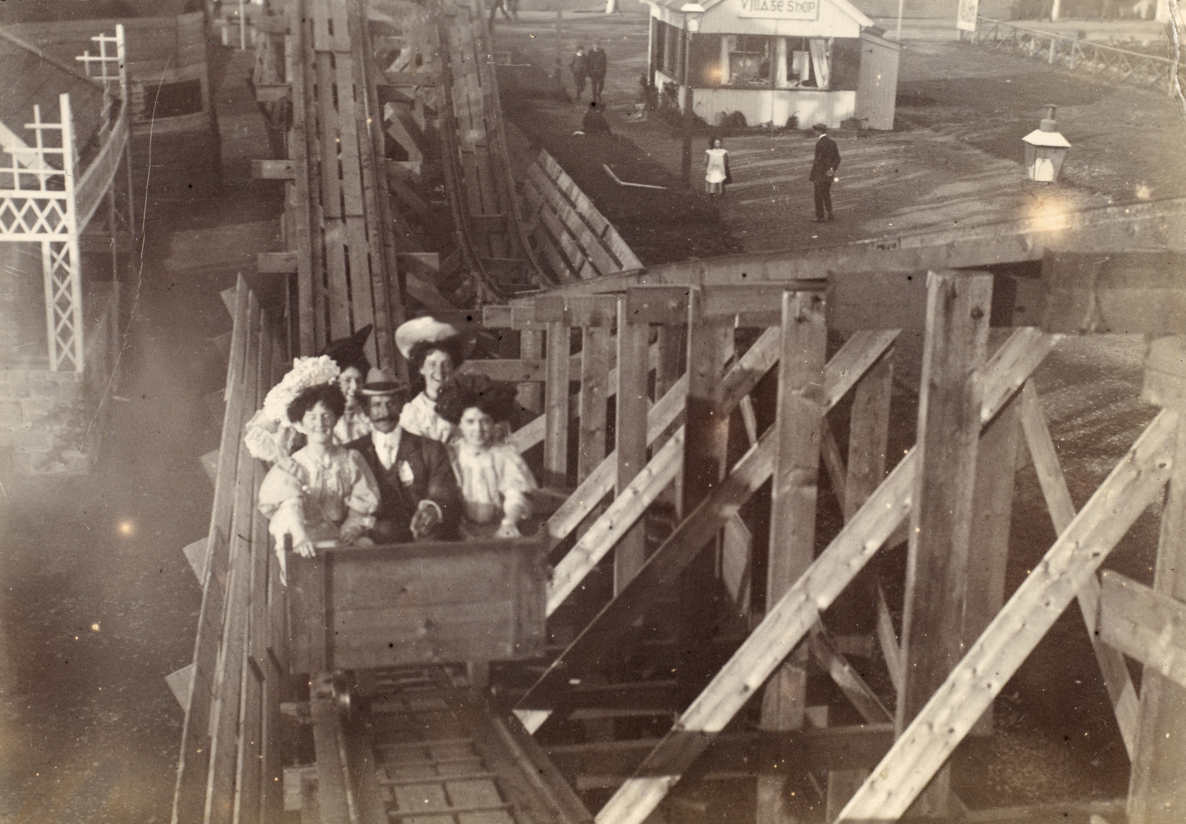A black and white photo of a family on a wooden rollercoaster