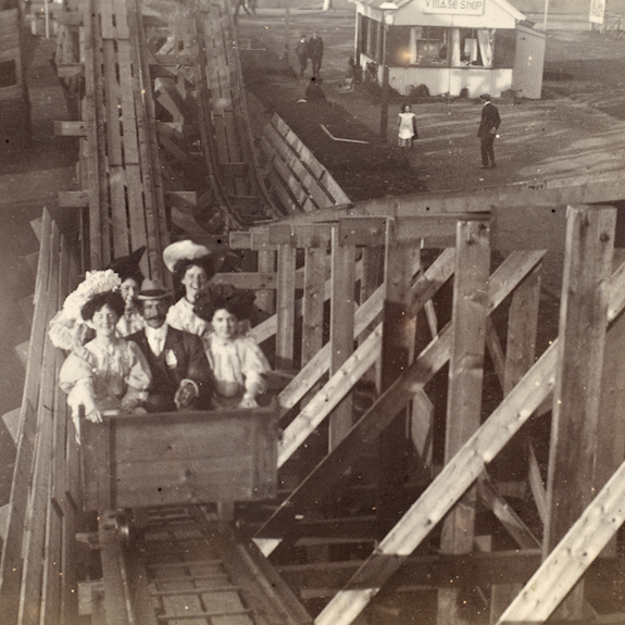 A black and white photo of a family on a wooden rollercoaster