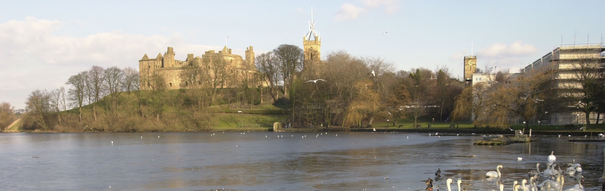View of a calm loch and a palace surrounded by trees