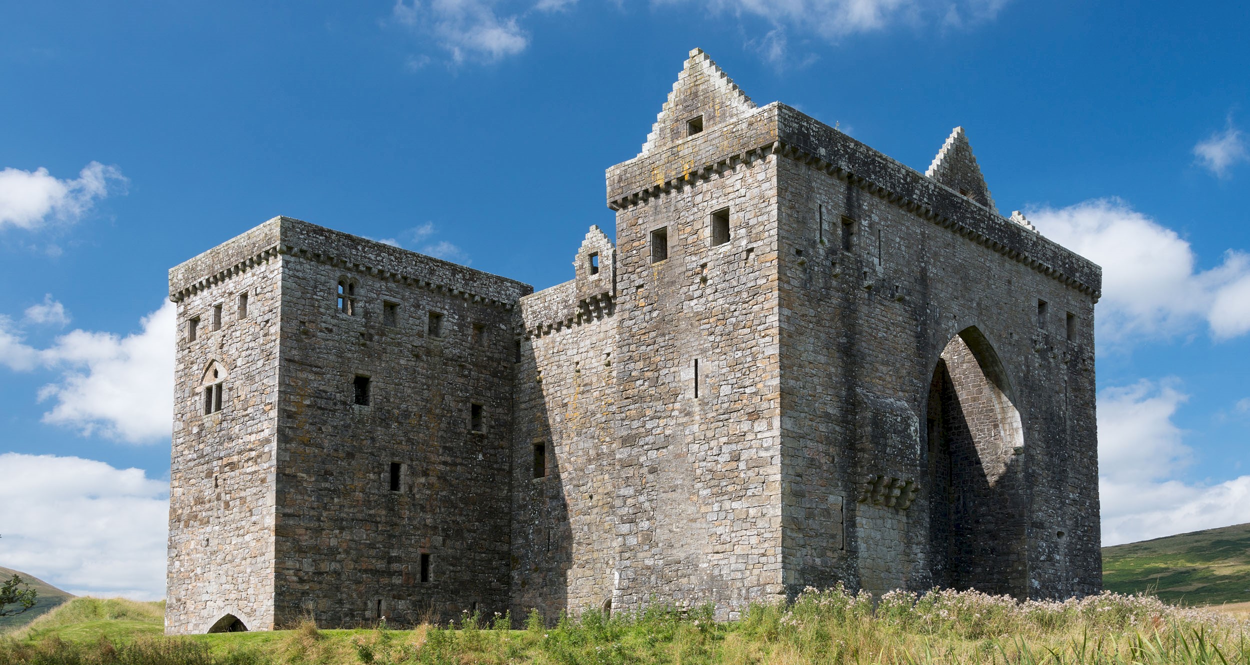 General view of Hermitage Castle with blue skies above