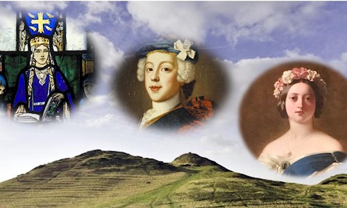 A grass covered hill with a loch at the bottom