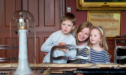 woman and kids viewing objects in the Convening Room at Trinity House