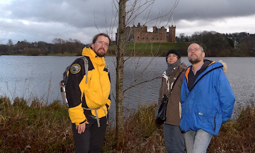 Photo of ranger and two visitors with Linlithgow Pallace in the ackground