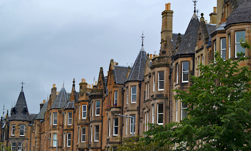 A row of sandstone tenements in the city with slate roofs