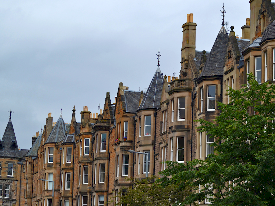 A row of sandstone tenements in the city with slate roofs