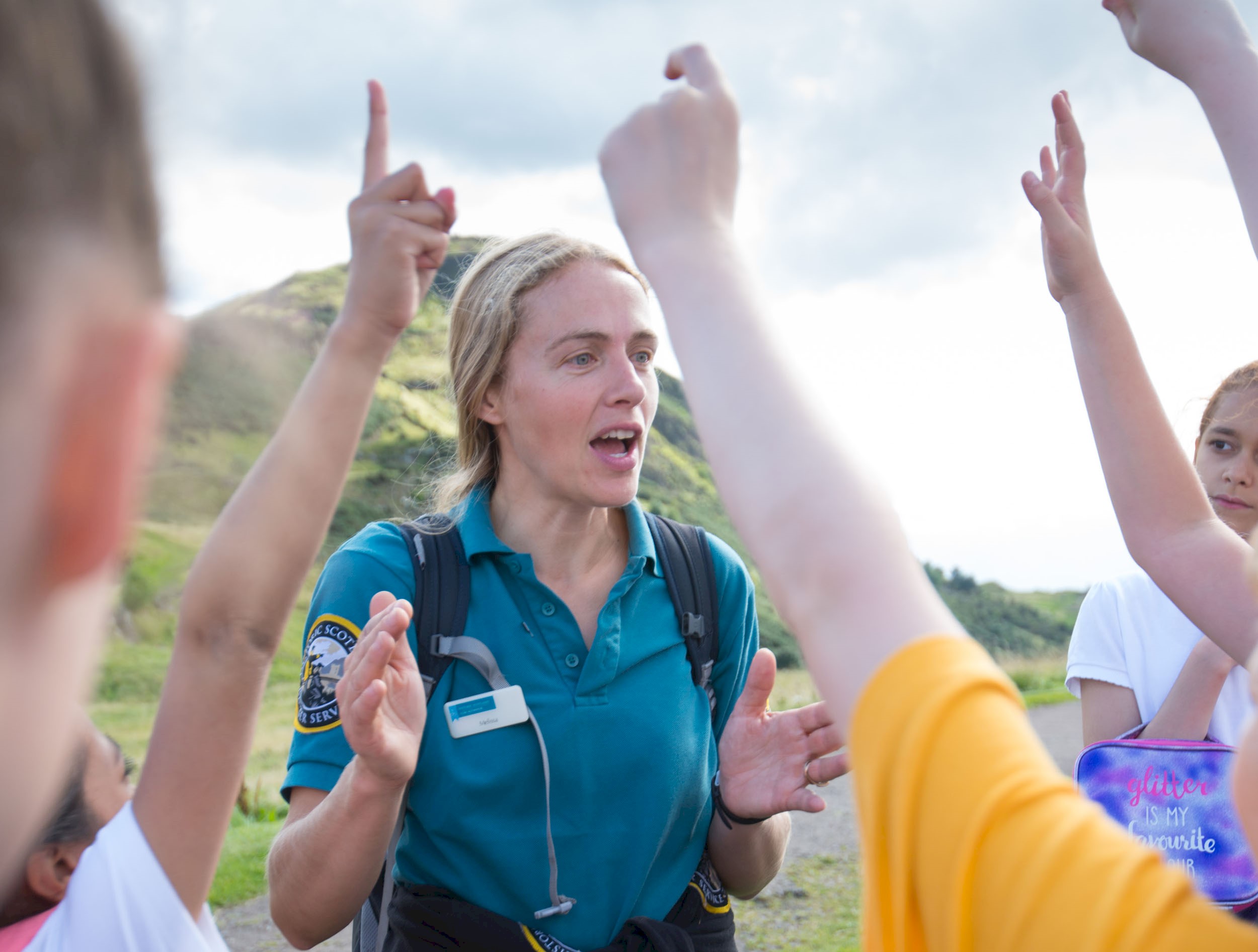 A Park Ranger talking to young people with their hands up