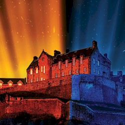 Edinburgh Castle illuminated in vibrant colors for the Castle of Light: Fire and Ice campaign. The left side of the castle glows with warm orange and red lights, while the right side is highlighted in cool blue tones, creating a dramatic fire and ice effect against the night sky.