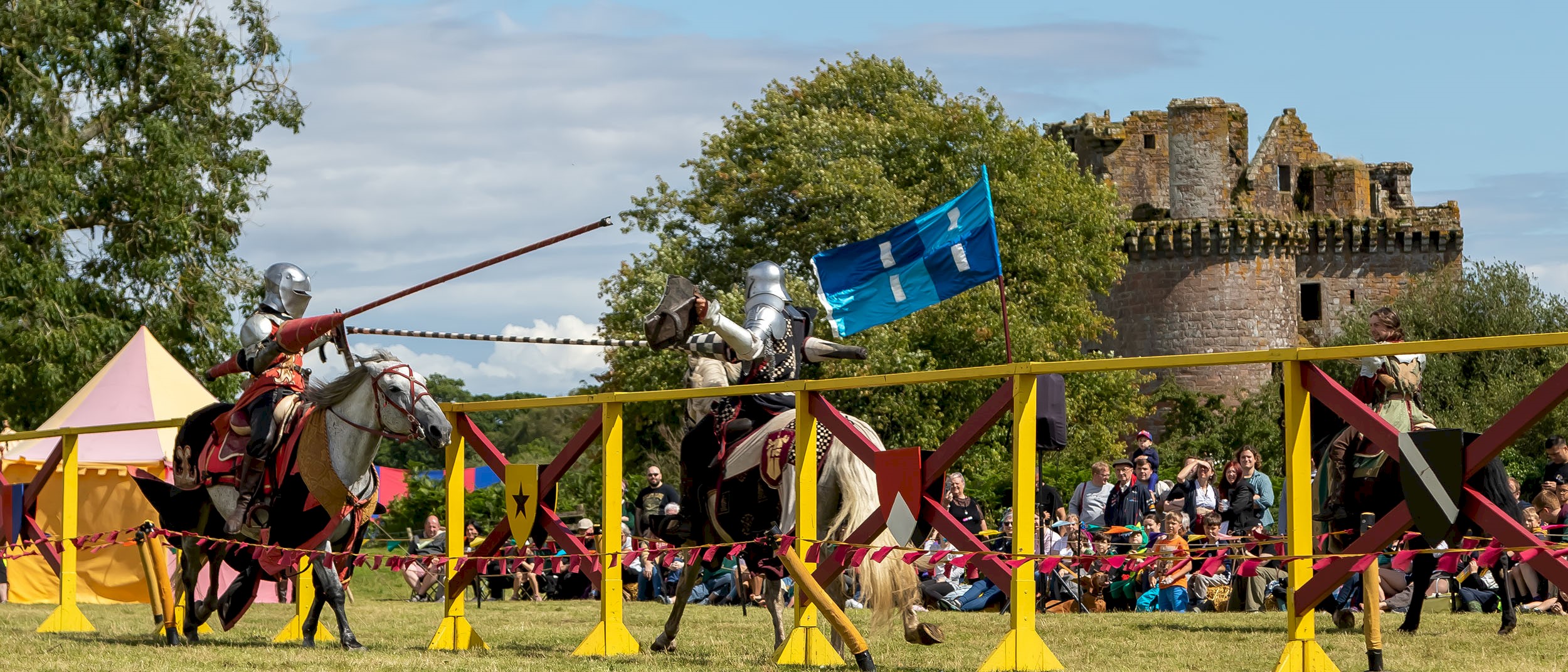 Two knights on horses taking part in a joust and wielding their lances as they approach each other