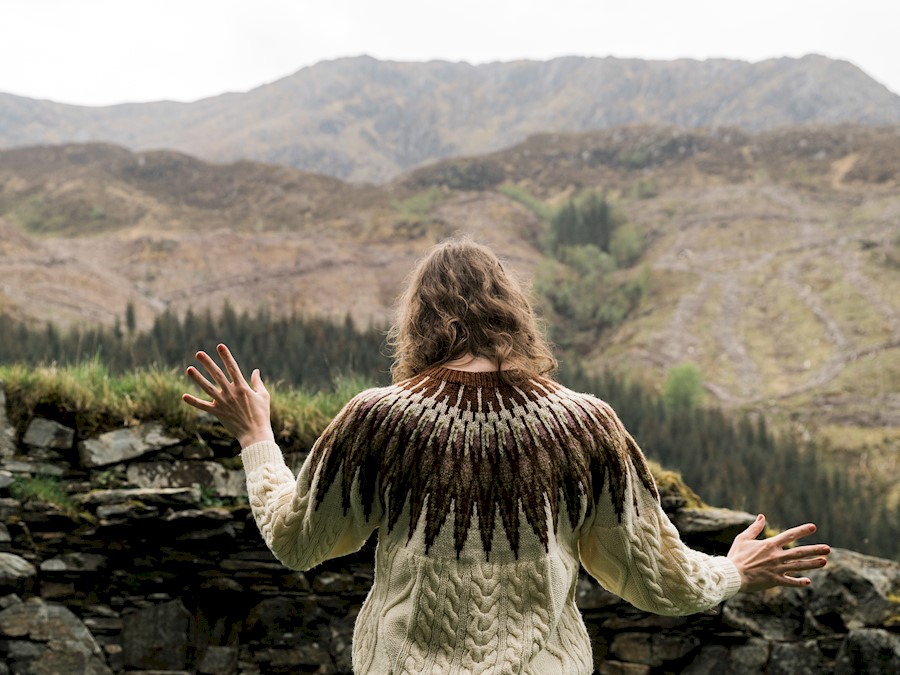 Person standing with arms outstretched in nature
