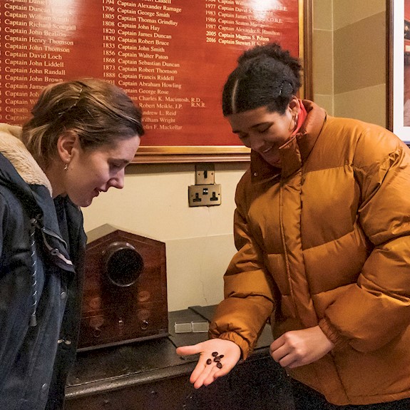 Two people looking at an item in Trinity House