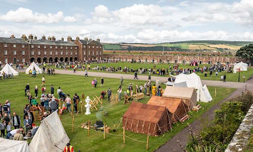 Visitors wandering round the living history camp in the grounds of Fort George 