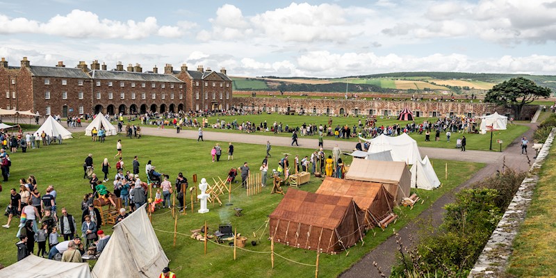 Visitors wandering round the living history camp in the grounds of Fort George 