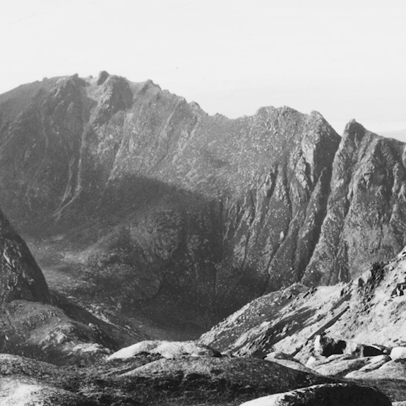 The boulder-strewn surface of Goat Fell summit in the foreground of this view of the famous Sleeping Warrior ridge in the Isle of Arran