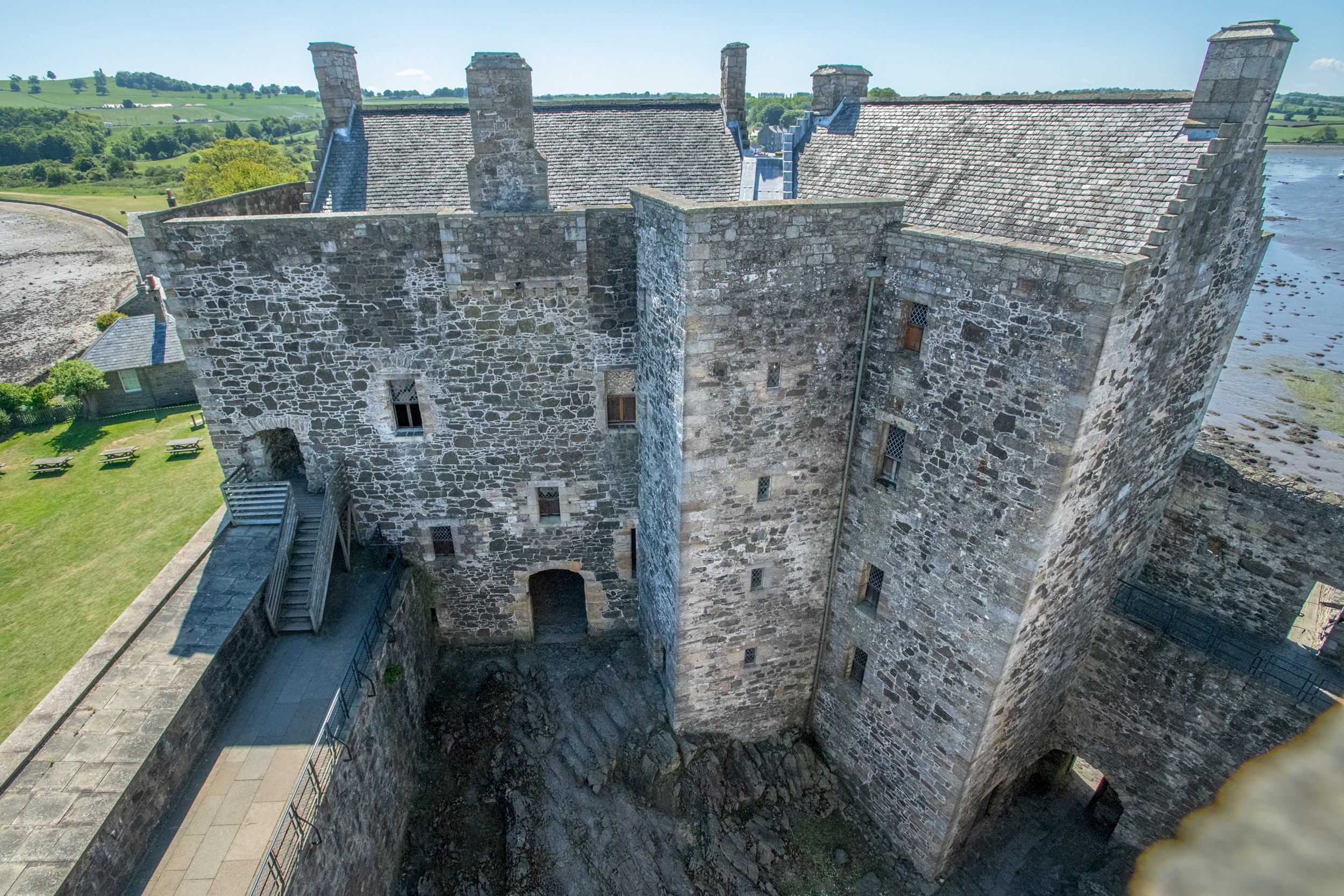 A large, stone square castle with a slate roof
