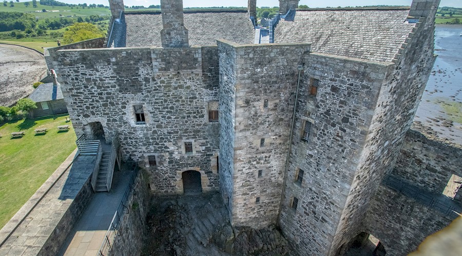 A large, stone square castle with a slate roof