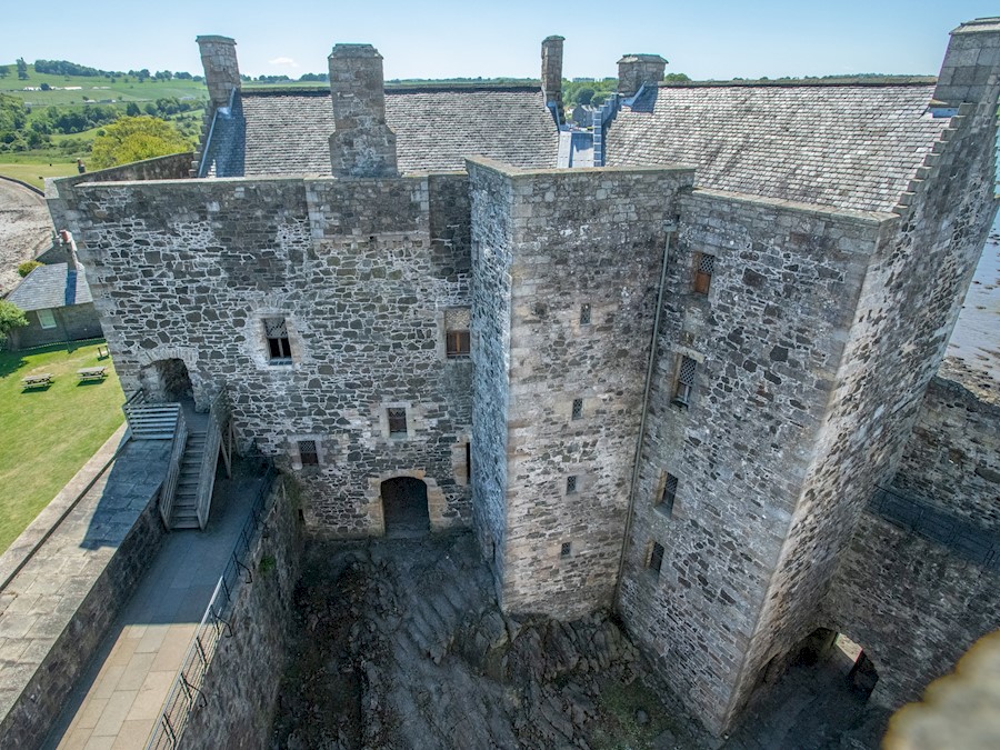 A large, stone square castle with a slate roof