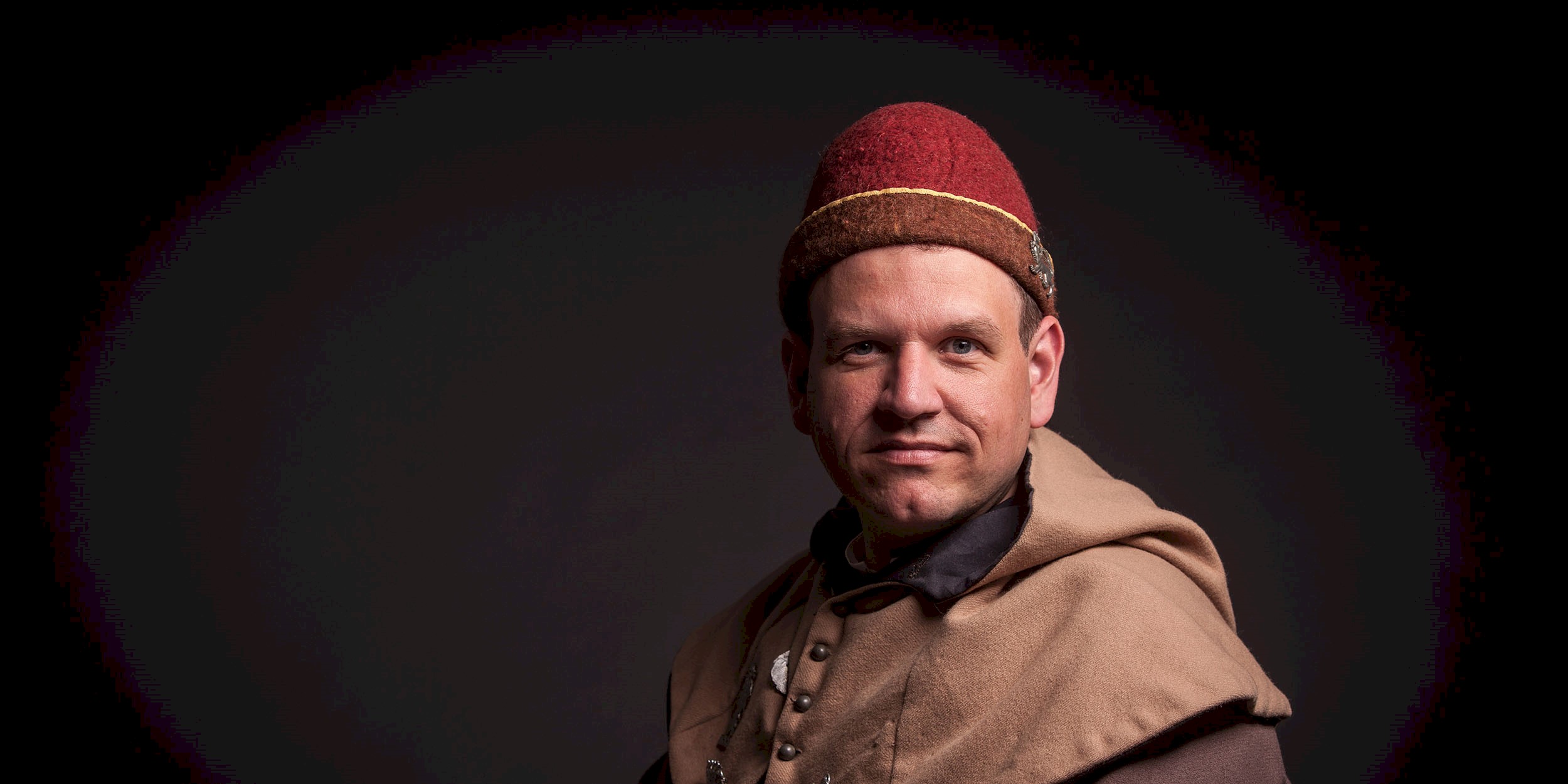 A man in medieval costume looking at the camera