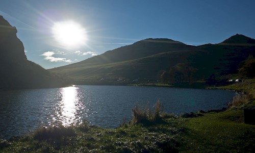 Blue sky and bright sunshine over Dunsapie Loch and the high road 