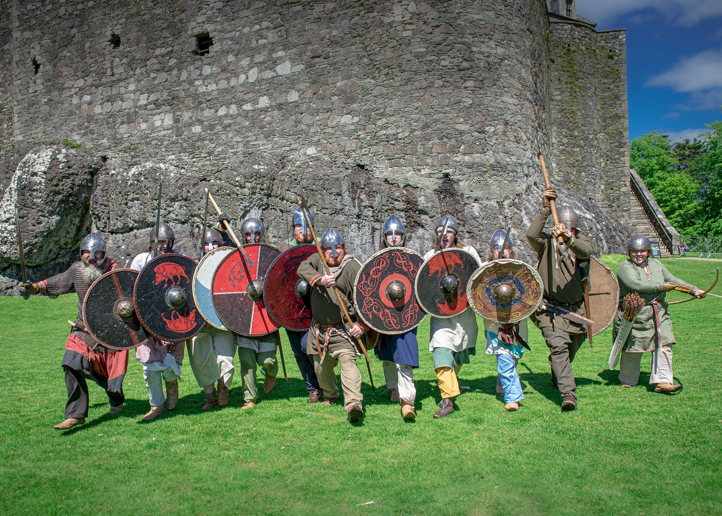 Costumed performers dressed as Norsemen at Dunstaffnage Castle wielding swords and shields