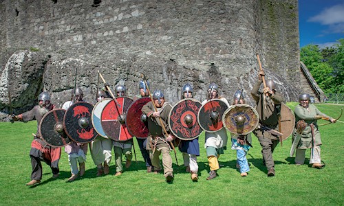 Costumed performers dressed as Norsemen at Dunstaffnage Castle wielding swords and shields