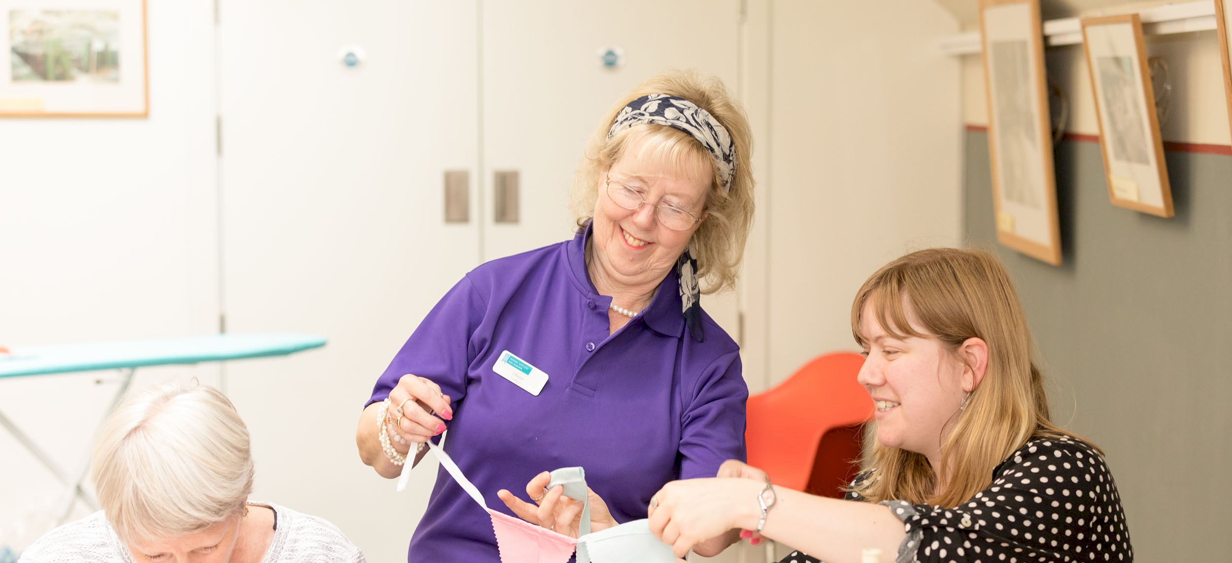 A volunteer holding bunting which visitors have sewn