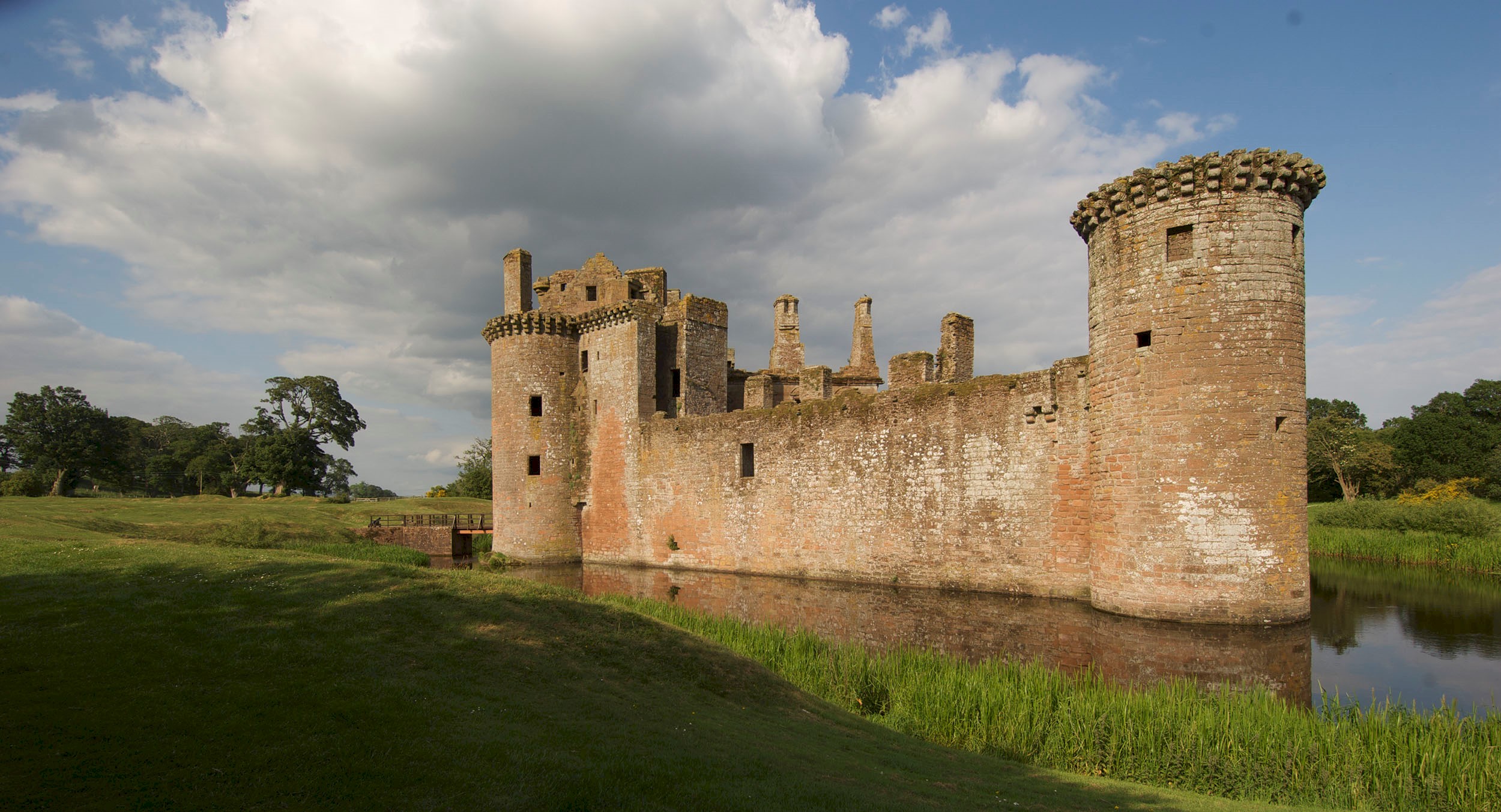 General view of the exterior of Caerlaverock Castle surrounded by a moat