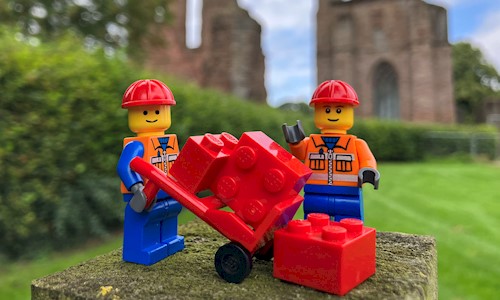 Lego figures standing on grass in the grounds of Arbroath Abbey