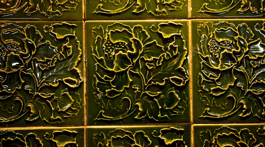 Green glazed wall tiles with a floral pattern sculpted into them
