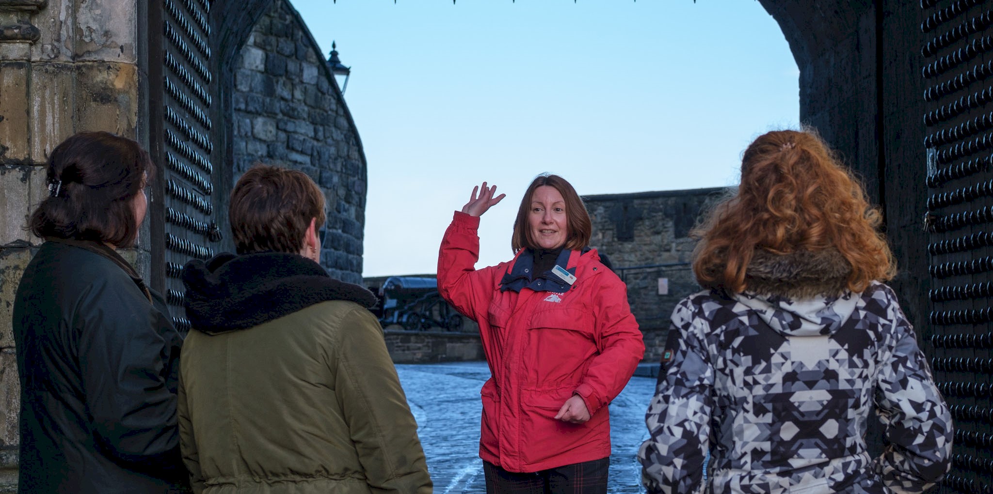 A castle tour guide facing visitors and talking to them
