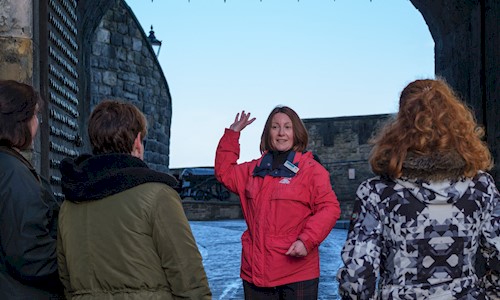 A castle tour guide facing visitors and talking to them