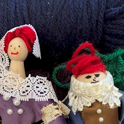 Two peg dolls with balls of wool behind them