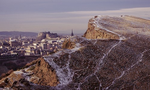 Salisbury Crags with light snow covering and Edinburgh Castle in the background