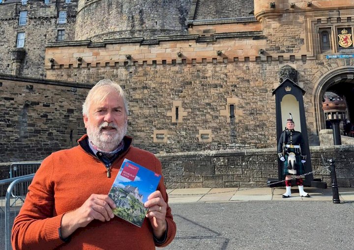 Peter Yeoman standing on the esplanade at Edinburgh Castle holding a guidebook
