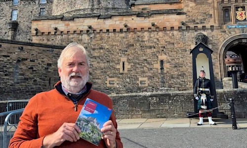 Peter Yeoman standing on the esplanade at Edinburgh Castle holding a guidebook