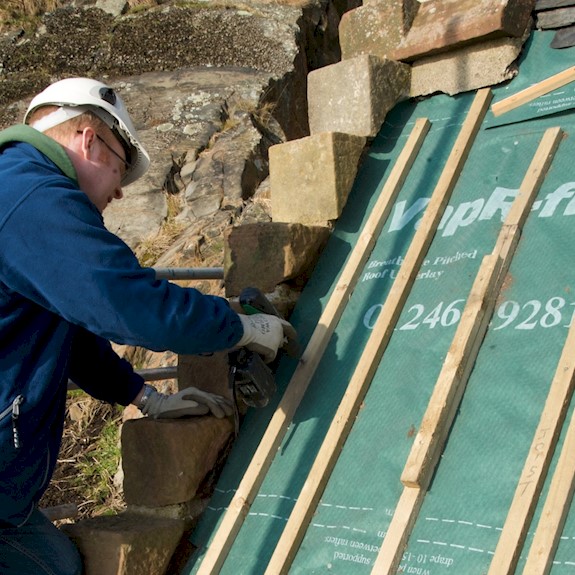 Man inspecting slates on a roof