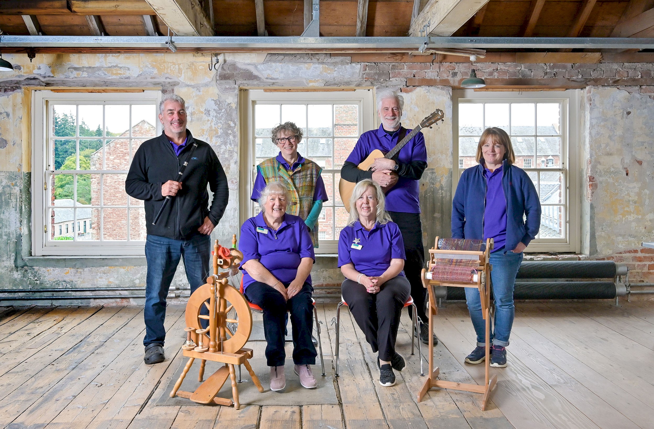 HES staff, two seated and four standing with some musical instruments around them