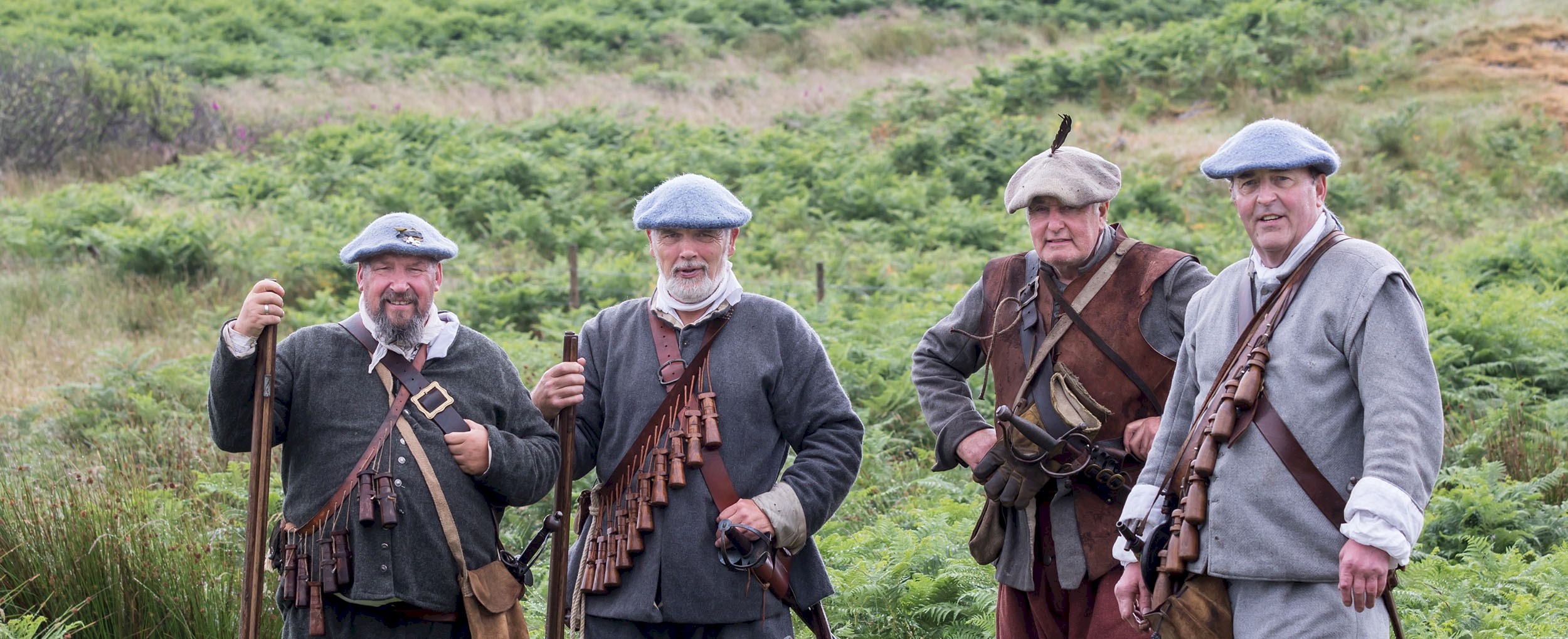 Four men dressed as Covenanters standing with muskets