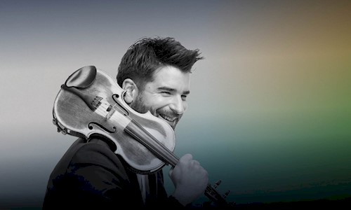 Christopher Bowen smiling and holding a violin over his right shoulder