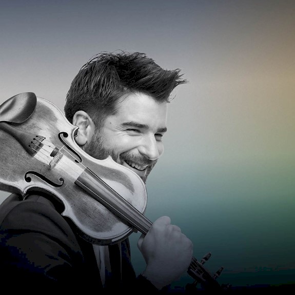 Christopher Bowen smiling and holding a violin over his right shoulder