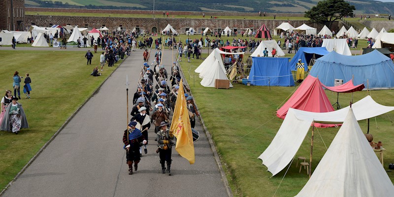 Costumed performers marching at Fort George