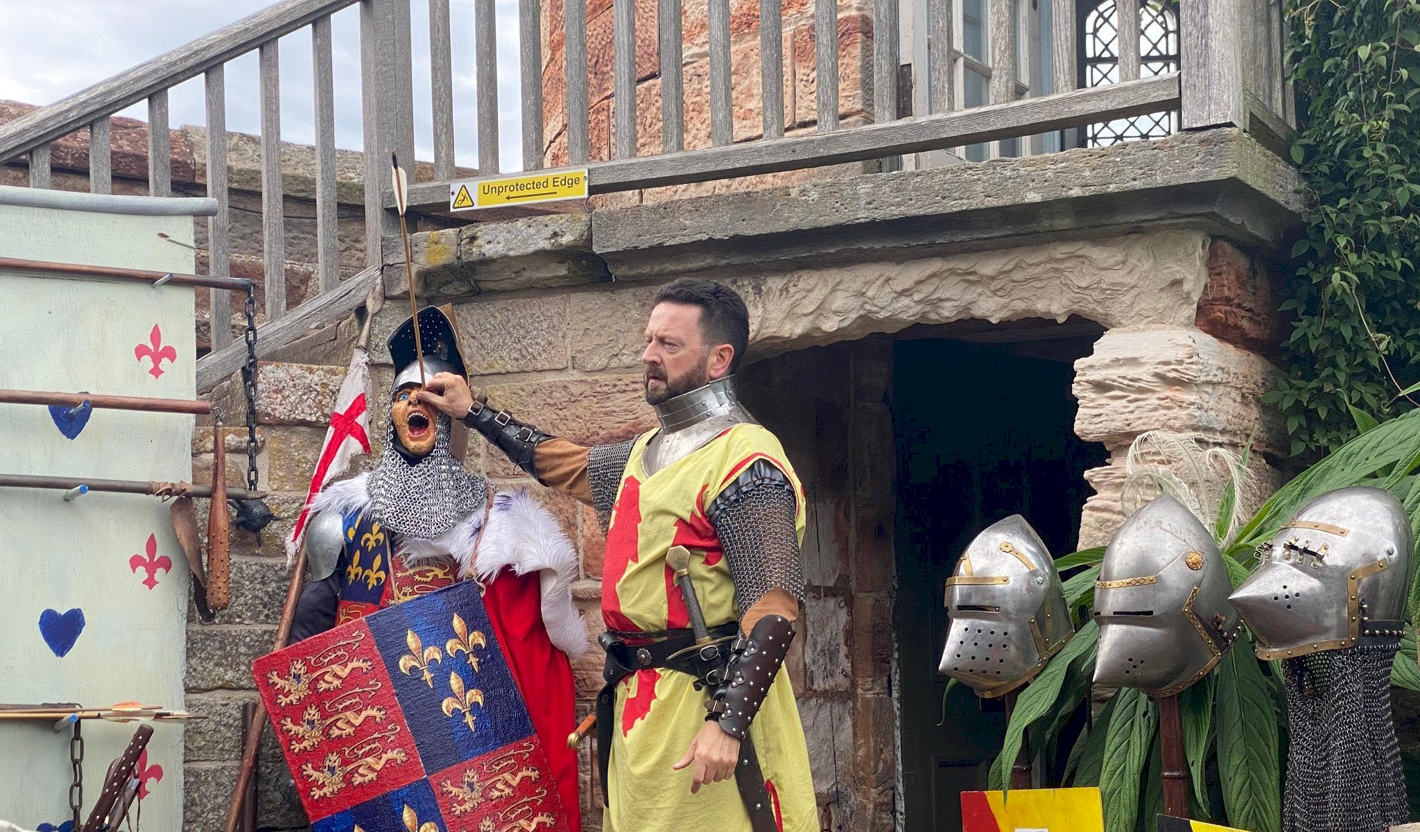 A Man at Arms putting an arrow in Prince Hal