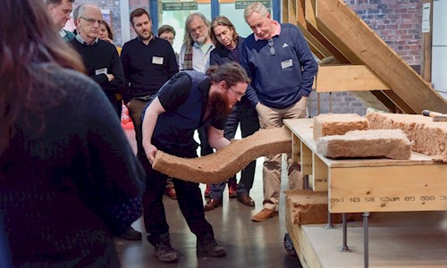A person demonstrating building energy efficiency to a group, using a display stand