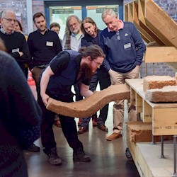 A person demonstrating building energy efficiency to a group, using a display stand