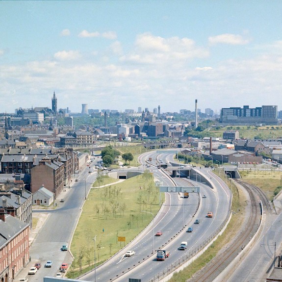 A view of a motorway with buildings surrounding