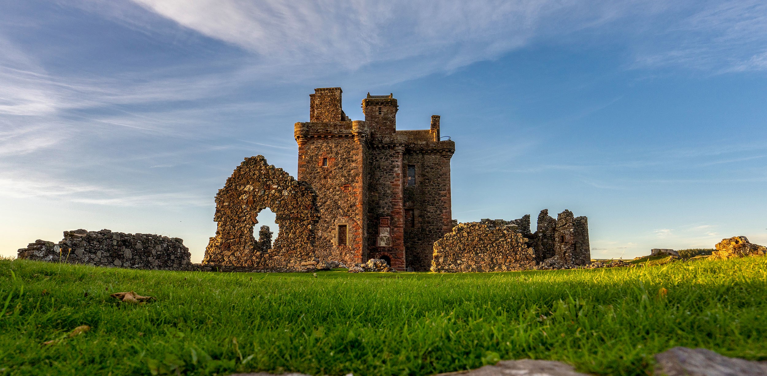 General view of a ruined castle with bright blue sky above