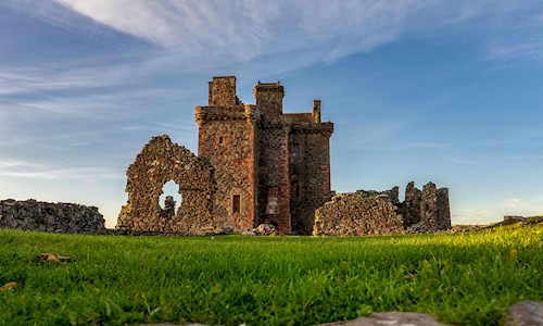 General view of a ruined castle with bright blue sky above