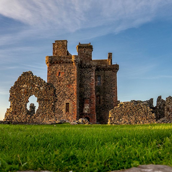 General view of a ruined castle with bright blue sky above