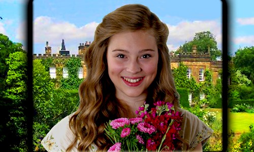 Young woman with long brown wavy hair holding a bouquet of hand picked flowers with a stately home in the background